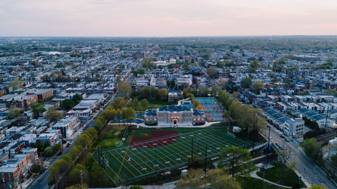 Aerial view of a Philadelphia neighborhood of rowhouses around a school and athletic field