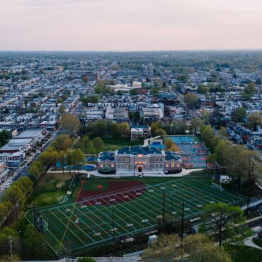 Aerial view of a Philadelphia neighborhood of rowhouses around a school and athletic field
