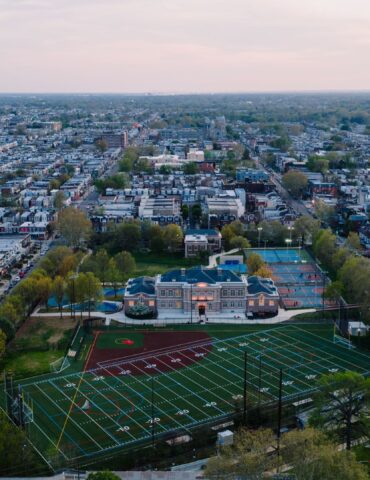 Aerial view of a Philadelphia neighborhood of rowhouses around a school and athletic field